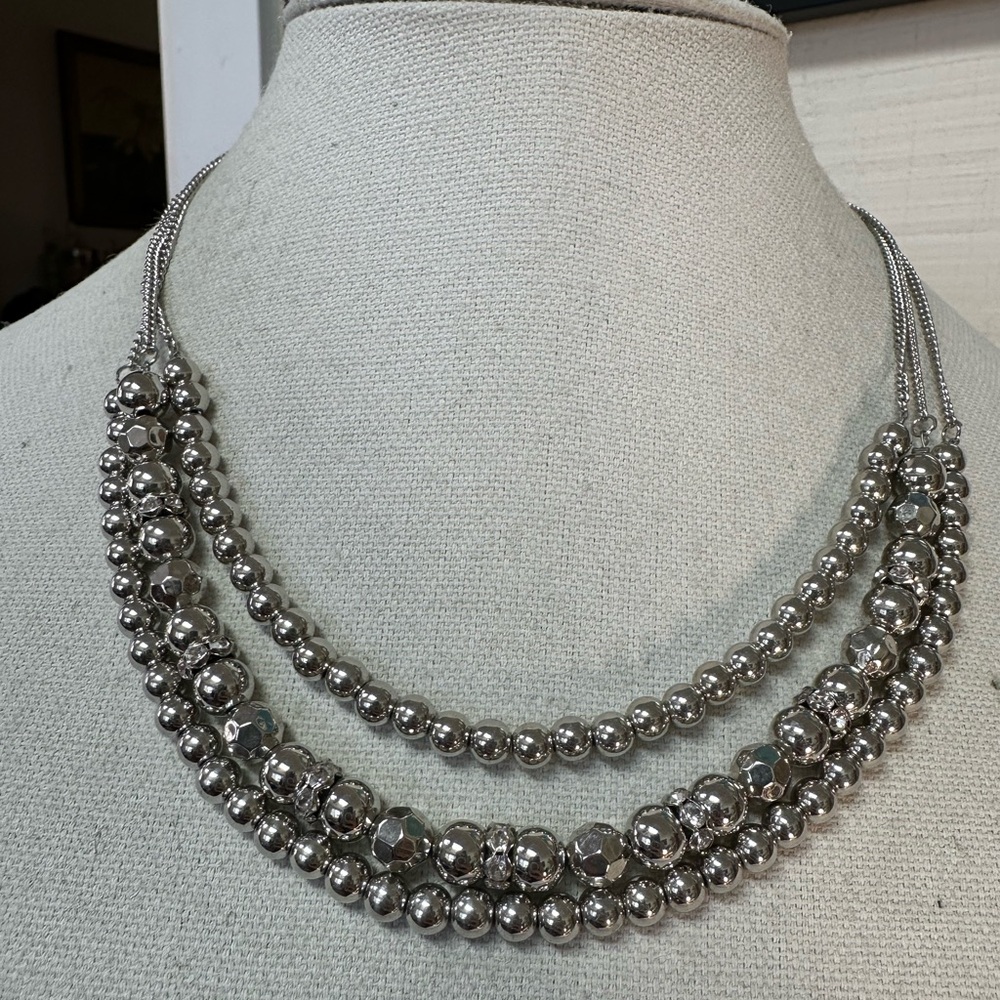 Triple strand silvertone necklace with rhinestone spacer beads
